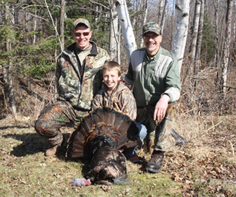 two-adult-turkey-menotors-and-youth-hunter-with-turkey